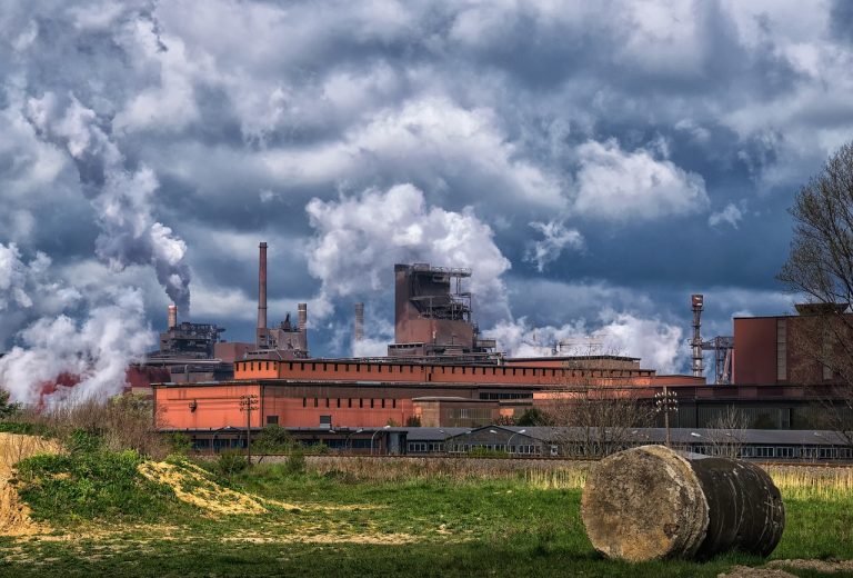 Jindal Steel Q2 results: integrated steel plant with blast furnace and smokestacks under heavy clouds