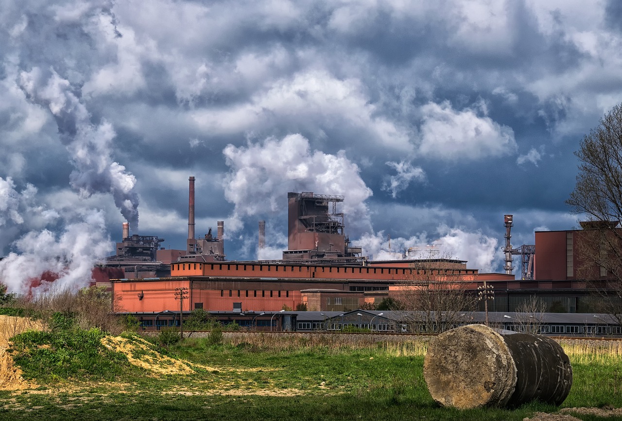 Jindal Steel Q2 results: integrated steel plant with blast furnace and smokestacks under heavy clouds