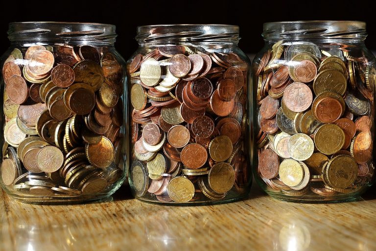 Free cash flow yield concept: three glass jars filled with coins, cash a business keeps after its spending
