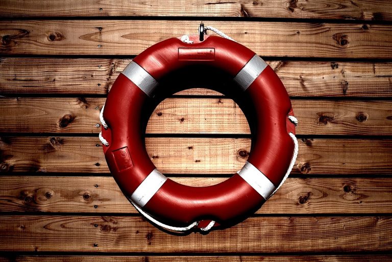 Altman Z-score concept: a red lifebuoy hanging on a wooden wall, a reminder to check a company for financial distress