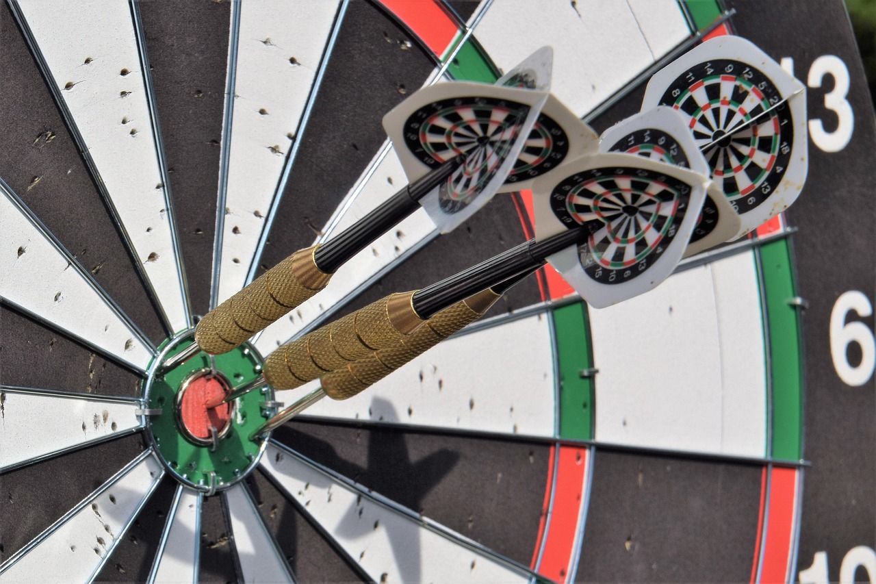 Information ratio concept: three darts grouped tightly on a dartboard, a symbol of consistent outperformance