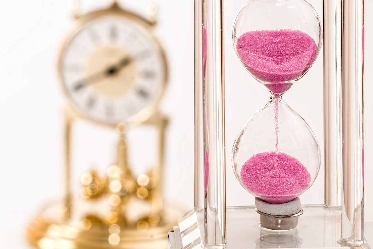 Bharat Bond ETF and target maturity: a pink-sand hourglass beside a gold mantel clock, a reminder that the fund has a fixed end date
