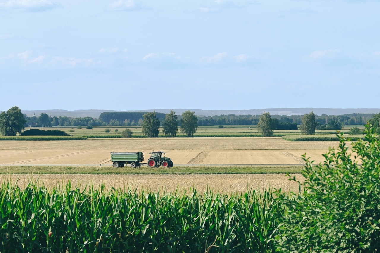Mahindra Finance Q2 results: a tractor pulling a trailer across harvested farm fields