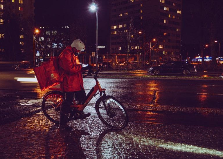 Swiggy Q2 results: a food delivery rider with an insulated bag on a city street at night