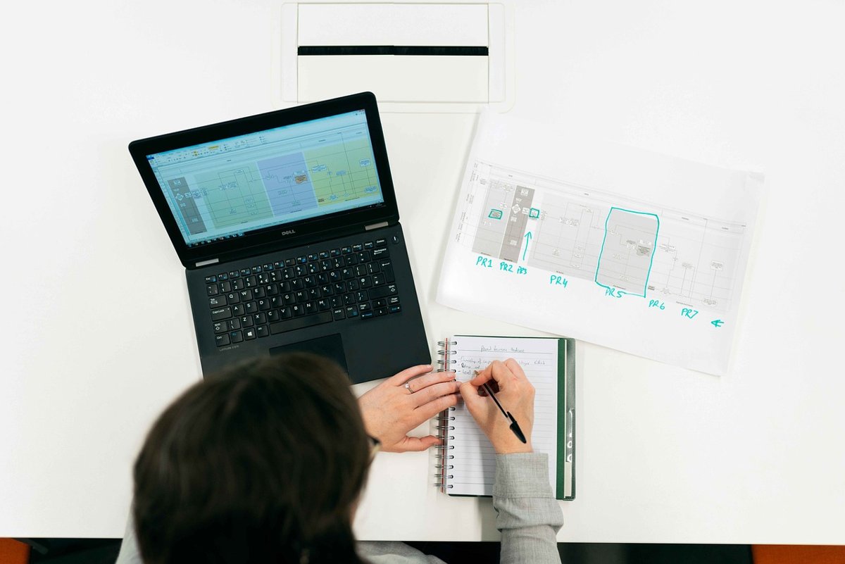 Cyient Q2 results: an engineer reviewing design drawings beside a laptop