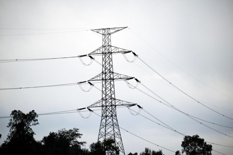 Adani Energy Solutions Q2 results: a high-voltage power transmission tower against a grey sky