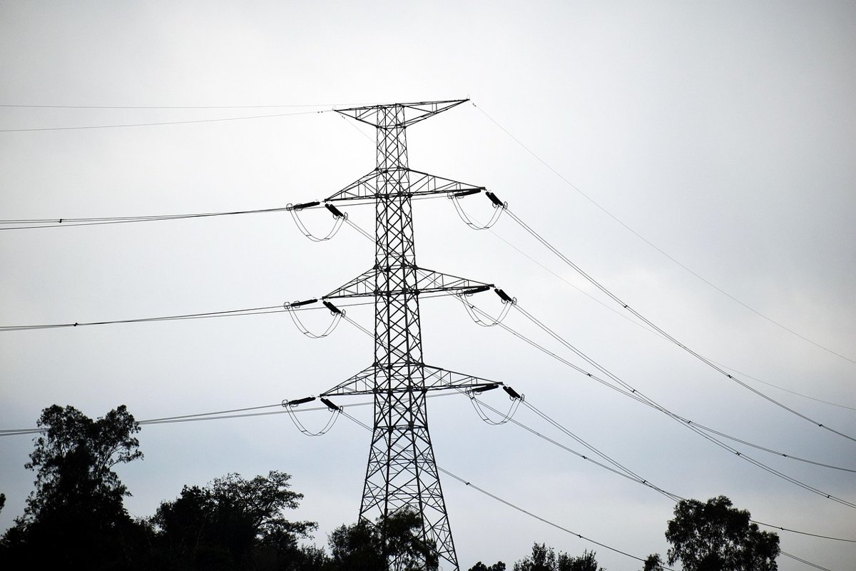 Adani Energy Solutions Q2 results: a high-voltage power transmission tower against a grey sky