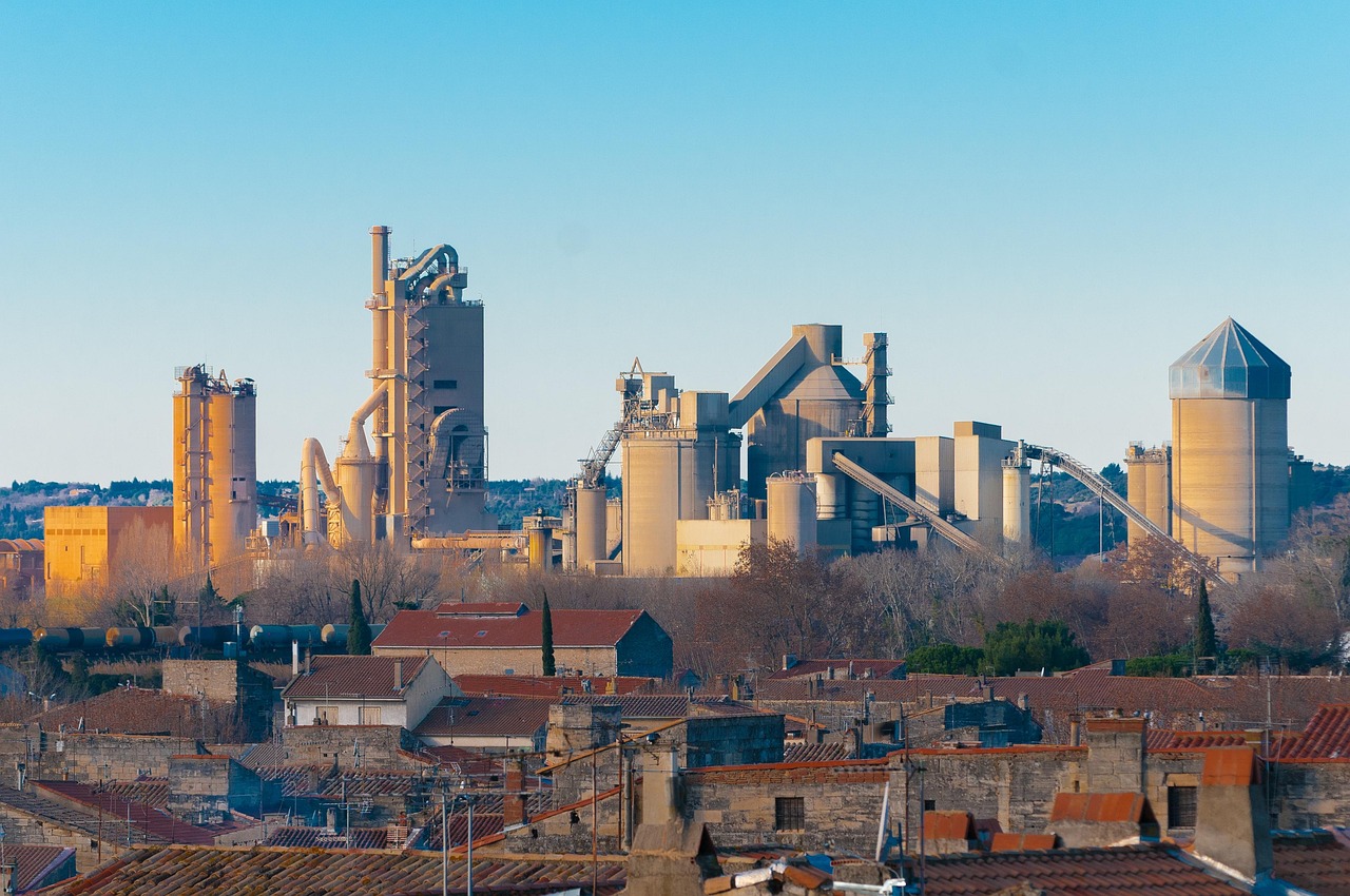 Nuvoco Q2 results: a cement plant with tall silos and kilns behind town rooftops