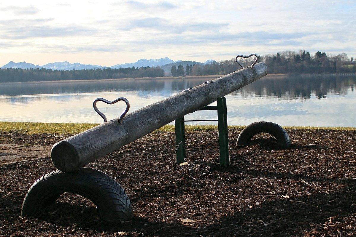 Bond duration explained: a wooden seesaw by a lake, tilted like bond prices and yields moving in opposite directions