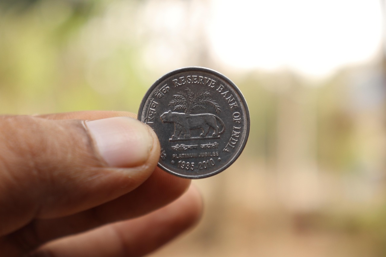 Yes Bank Moody's rating: a hand holding an Indian rupee coin issued by the Reserve Bank of India