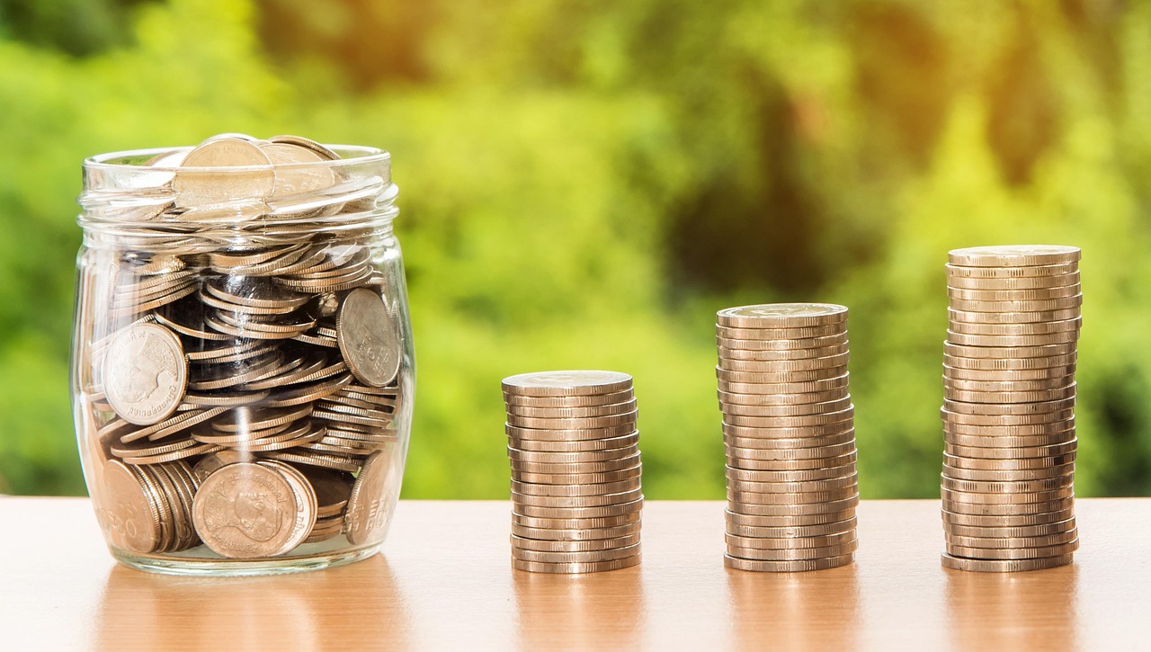 IOB Q2 results: a jar of coins beside rising stacks of coins