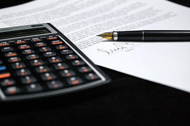 IPO issue expenses: calculator, fountain pen and a signed agreement on a desk