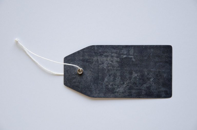 IPO price band revision: a blank dark price tag on a white string, ready to be relabelled