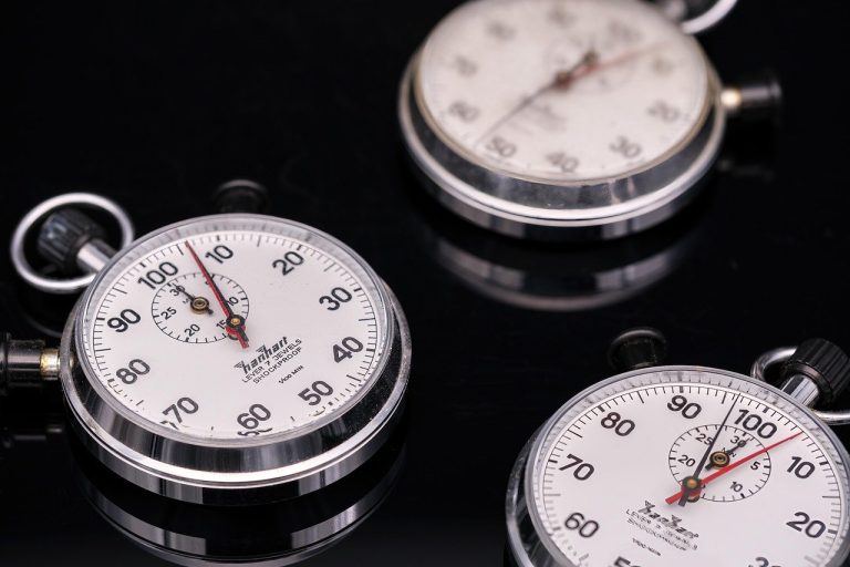 IPO T+3 listing timeline concept: three stopwatches on a dark reflective surface
