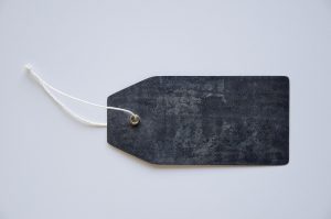 IPO underpricing: a blank dark price tag on a string against a plain white background