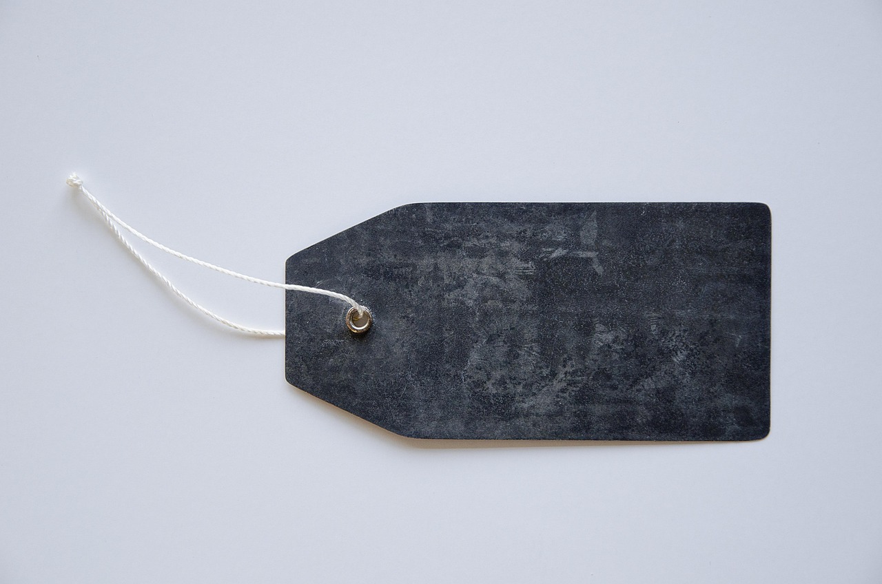 IPO underpricing: a blank dark price tag on a string against a plain white background