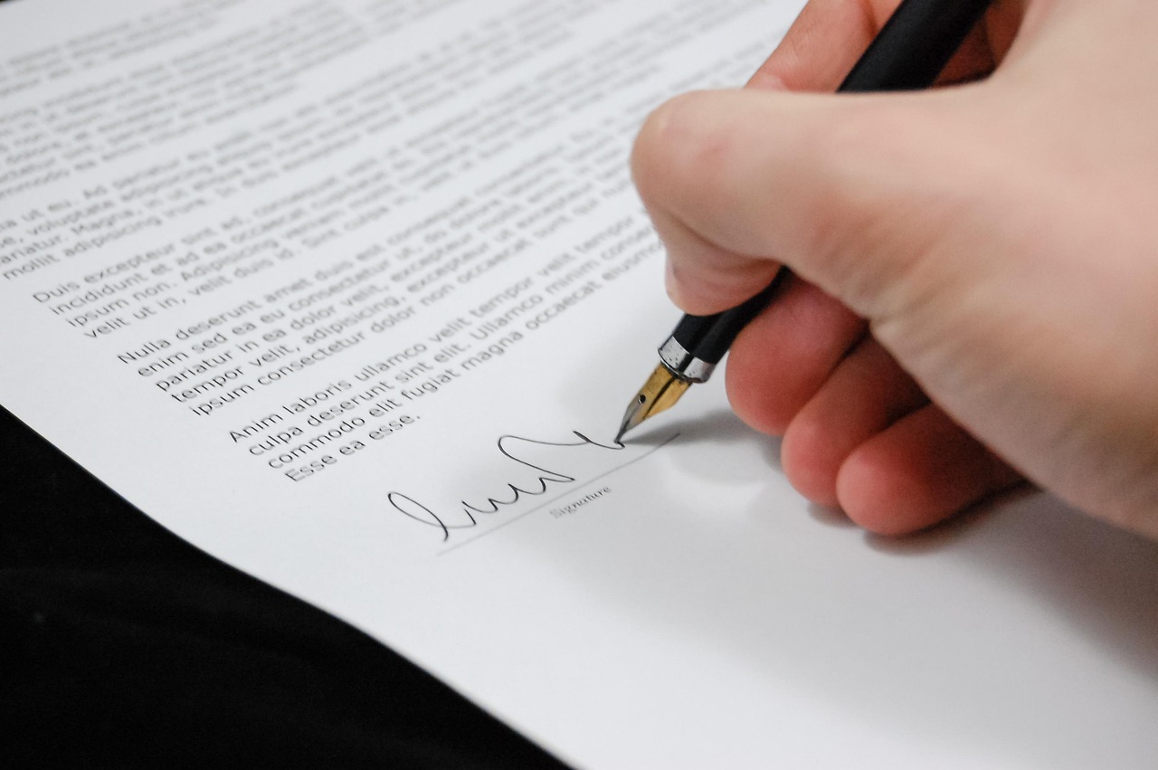 IPO underwriting in India concept: hand signing an underwriting agreement document with a pen