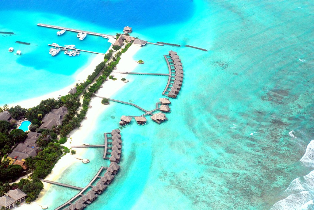 Island reversal pattern: aerial view of a small island ringed by turquoise sea, cut off from the mainland