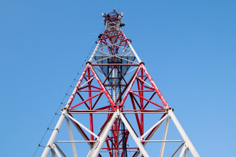 Jio Platforms IPO anchor investors: a red and white telecom tower seen from below against a clear blue sky