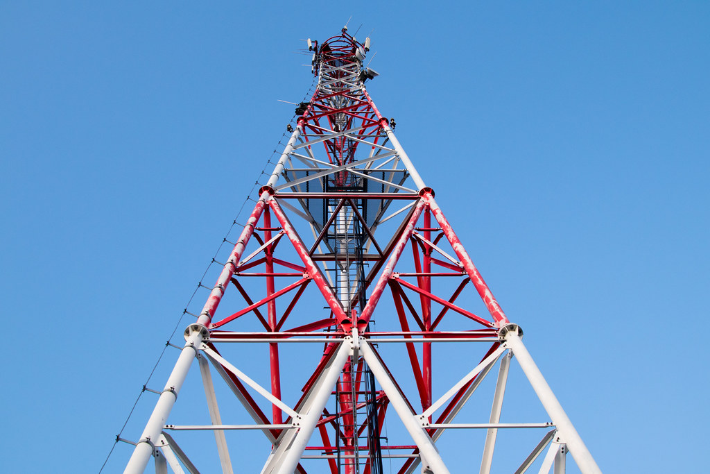 Jio Platforms IPO anchor investors: a red and white telecom tower seen from below against a clear blue sky