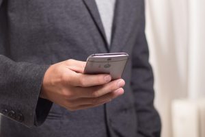 Jio Platforms Q2 results: a mobile subscriber in a suit using a smartphone