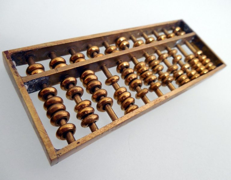 Kagi chart concept: an old brass abacus on a plain white surface