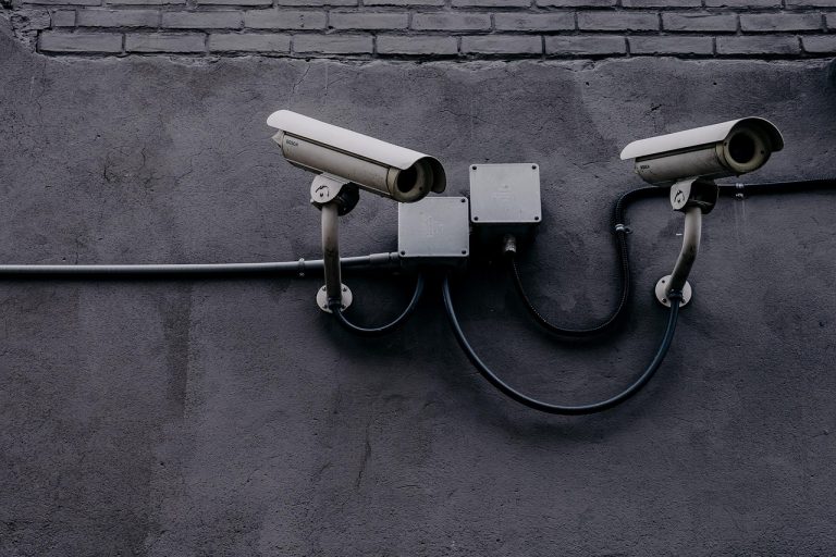 Kapston Services Q2 results: two CCTV security cameras mounted on a grey wall