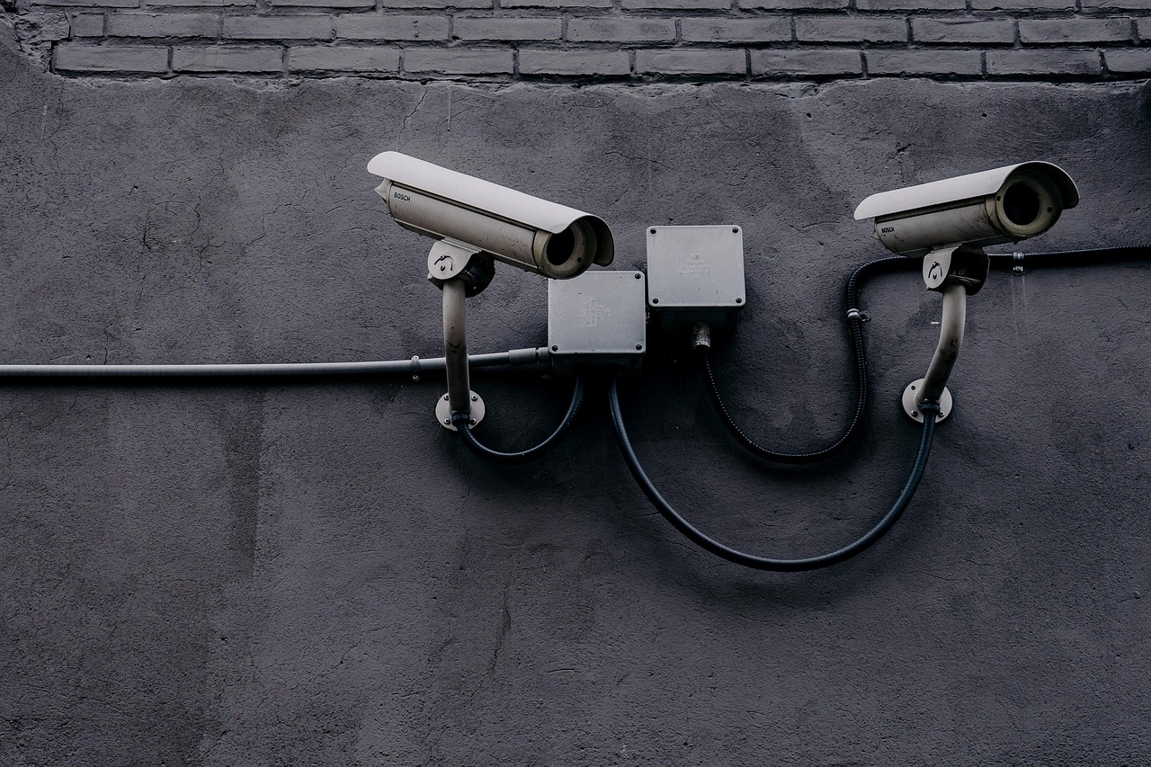 Kapston Services Q2 results: two CCTV security cameras mounted on a grey wall