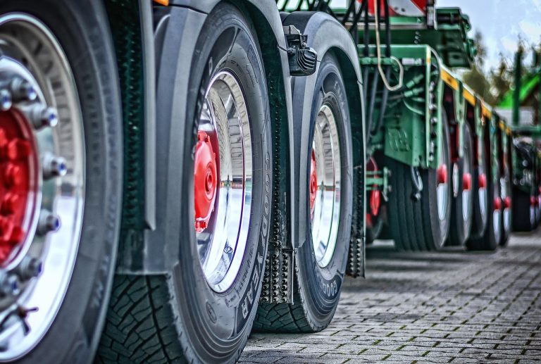 Kross Q2 results: close-up of heavy trailer axles and tyres lined up on a paved yard