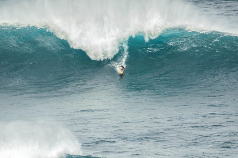 Momentum investing strategy in India: a surfer riding down the face of a large breaking wave