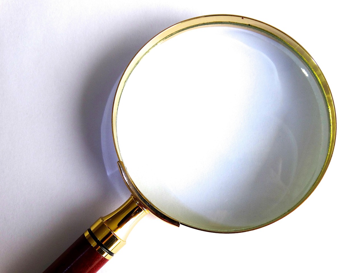 Monitoring agency report: a brass magnifying glass resting on a white sheet