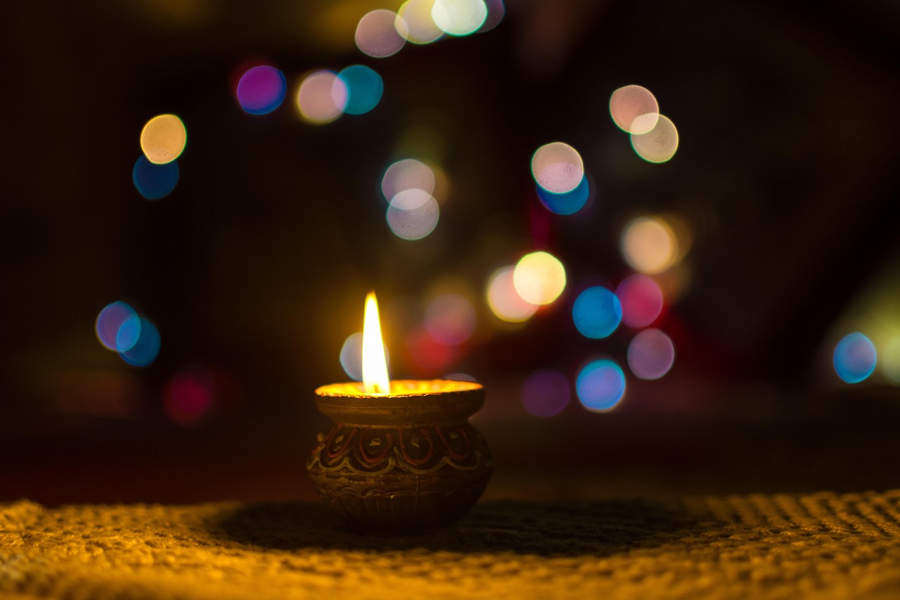Muhurat trading 2026: a lit clay diya glowing against colourful Diwali bokeh lights