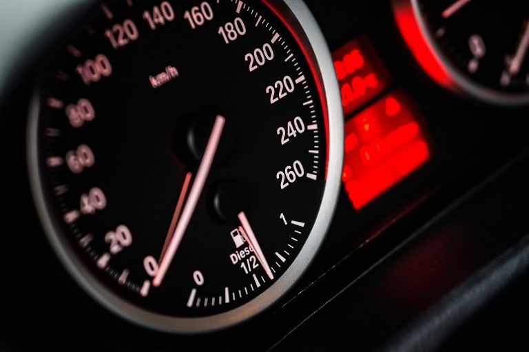 Mutual fund riskometer: close-up of a dashboard dial with its needle against red-lit gauges