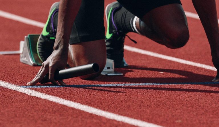 Nifty futures rollover: a sprinter holding a relay baton at the starting blocks on a running track