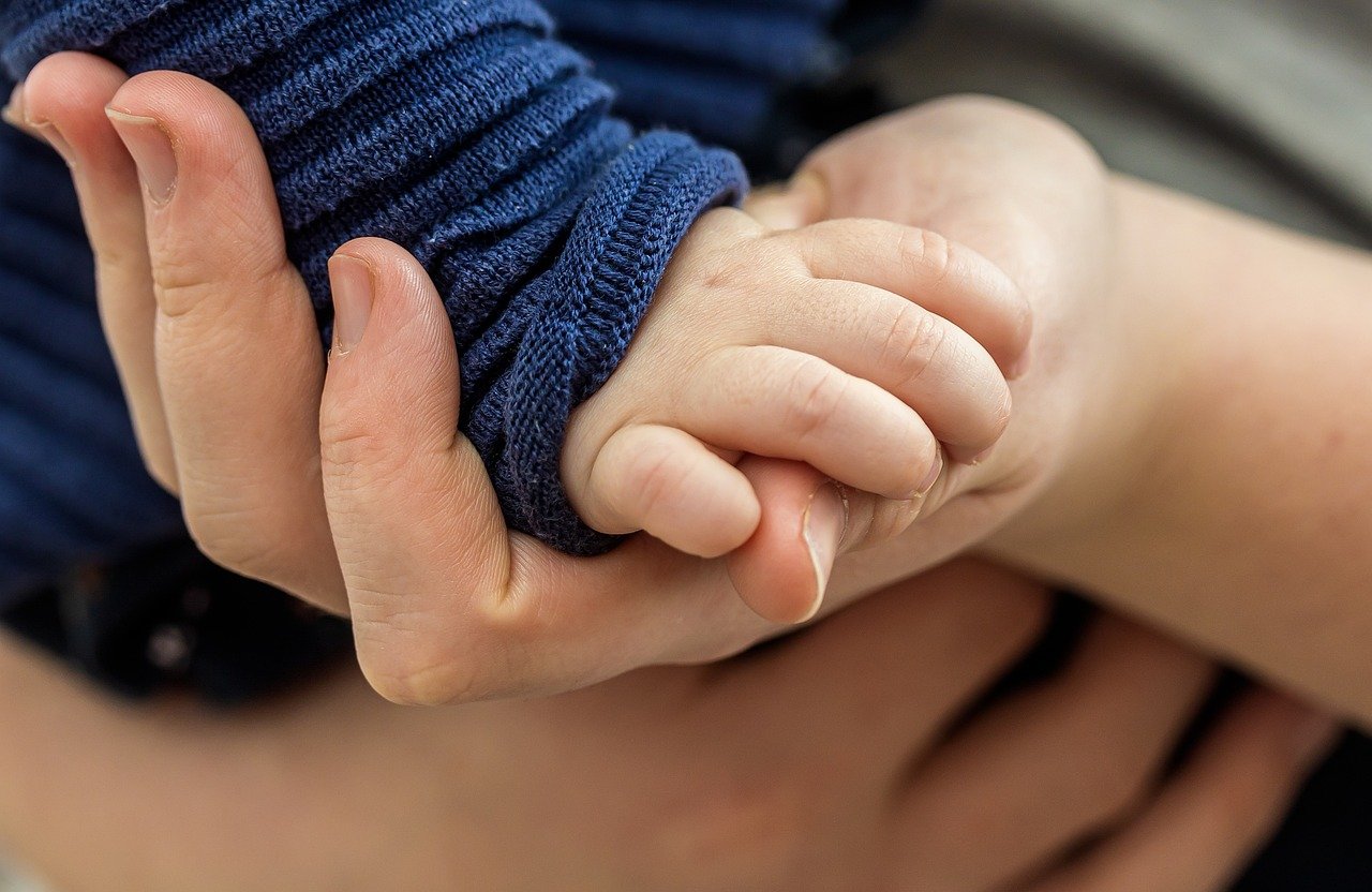 Nomination in demat account: a parent holding a small child's hand