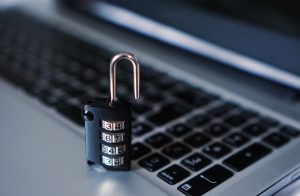 NSE broker inspection lapses: a combination padlock resting on a laptop keyboard