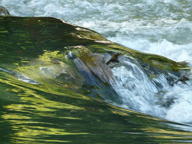 On balance volume indicator concept: fast river water flowing over mossy rocks