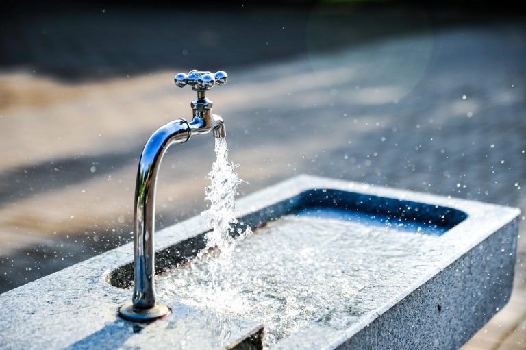 Operating cash flow vs net profit: water flowing from a steel tap into a stone basin, like cash flowing into a business