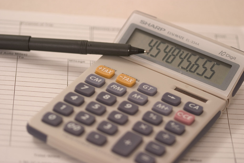 Other comprehensive income in results: a calculator and pen resting on a ruled accounts ledger