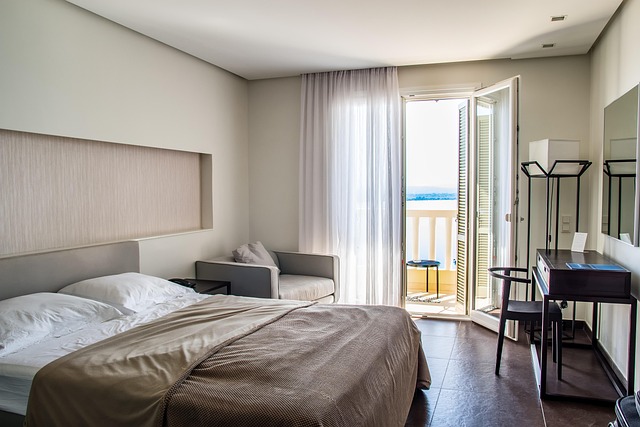 OYO Moody's outlook: a made-up hotel room with a double bed and an open balcony door