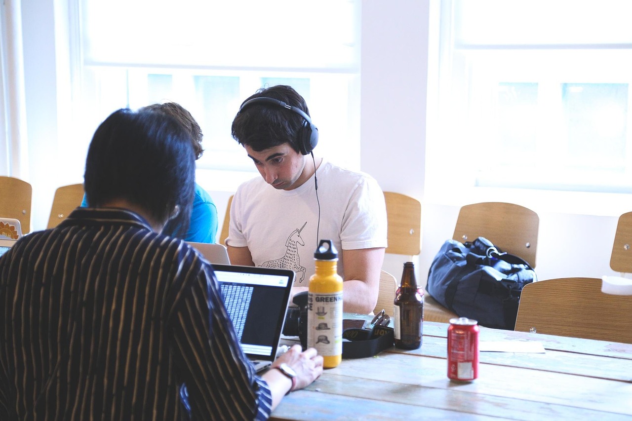 Innovators growth platform: young startup team working on laptops at a shared wooden table