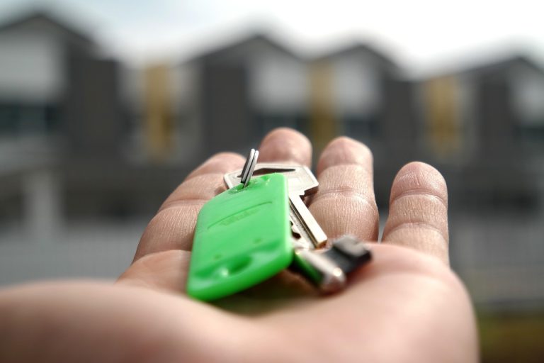 Piramal Finance Q2 results: house keys resting on an open palm in front of a row of new homes