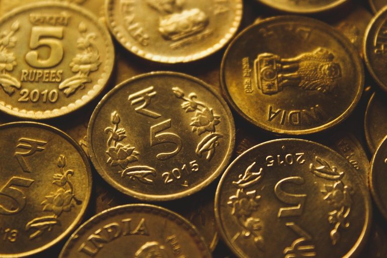 PNB profit target: close-up of Indian five-rupee coins piled together in warm light