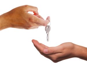 Pre-sales real estate results: a developer hands a house key to a buyer at handover, the point where handover-based developers book revenue