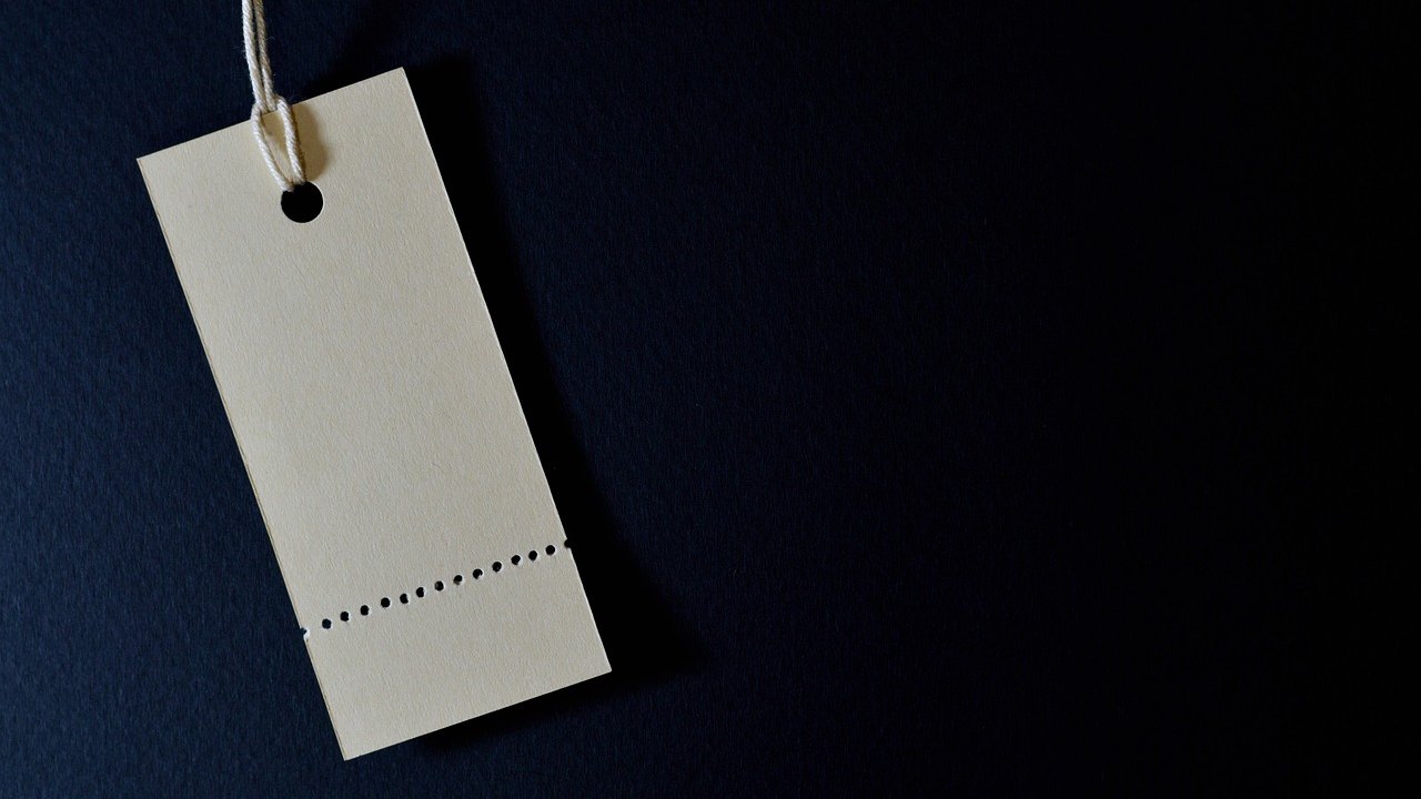 Price band in IPO: a blank paper price tag hanging on a string against a dark blue background