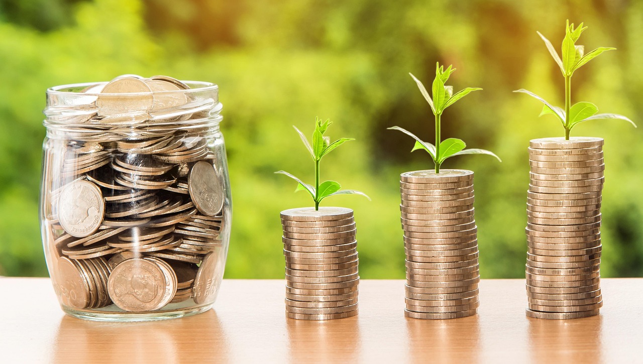 Profit factor in trading: rising stacks of coins with seedlings beside a jar of coins
