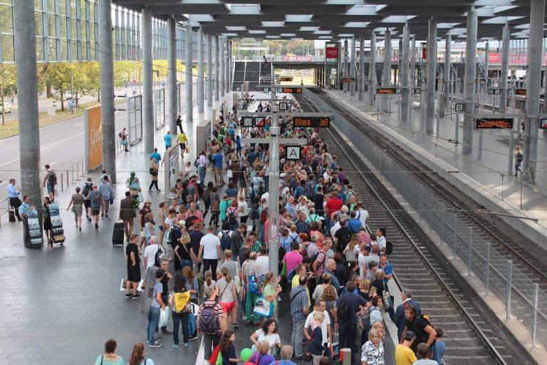 Positive volume index concept: a large crowd of commuters packed onto a busy railway platform