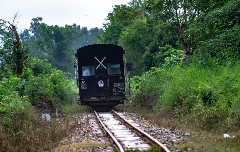 RailTel order win: an Indian Railways coach on a single track through green countryside