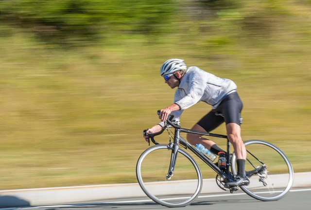 Rate of change indicator idea: a road cyclist riding fast past a motion-blurred green hillside, showing speed of movement