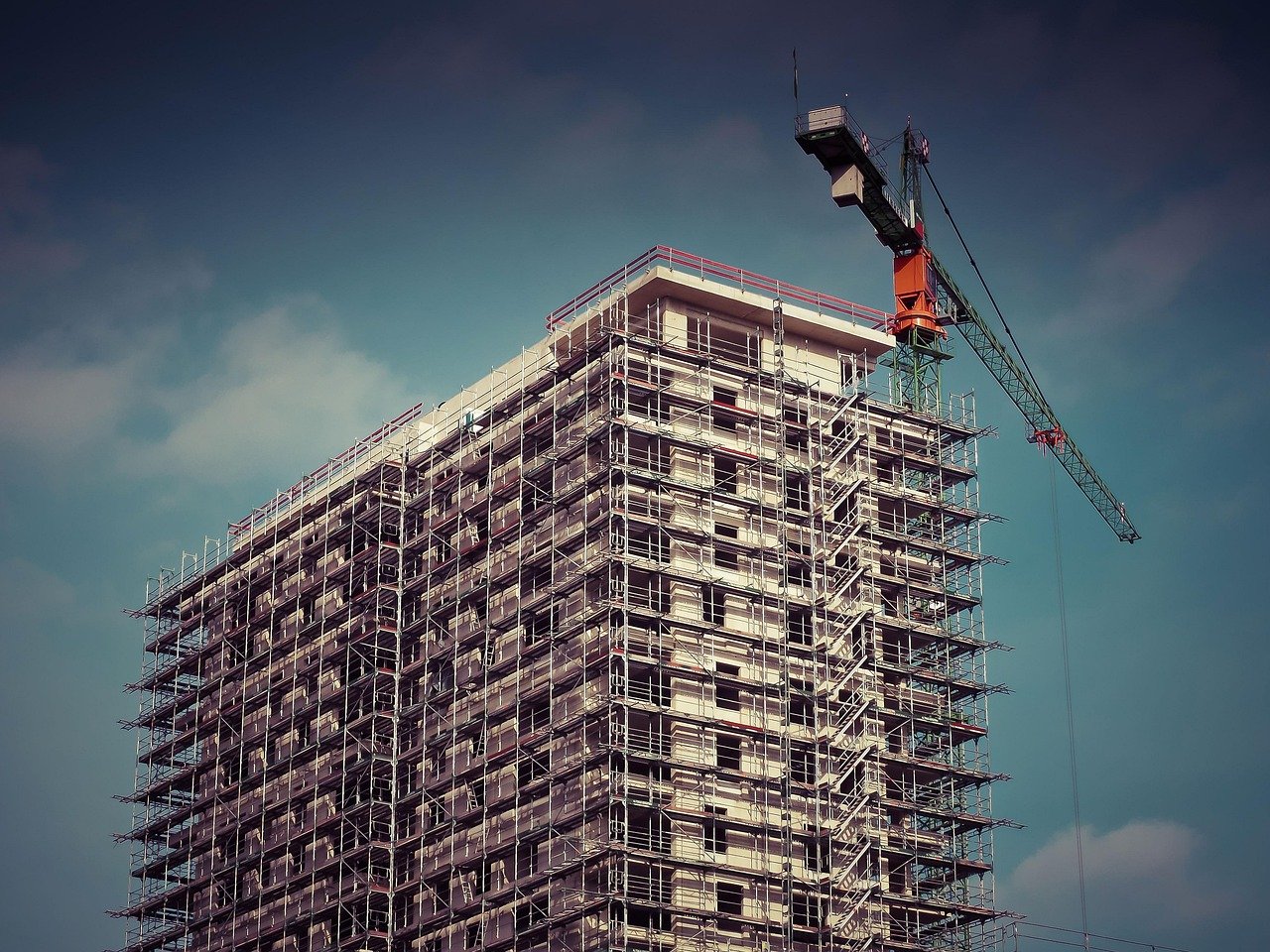 Raymond Realty Q2 results: residential tower under construction with scaffolding and a crane